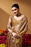 Seated close view of the saree drape and decorative border.