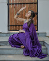 Model seated in a purple checked saree, showing the drape and blouse pairing.