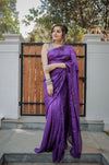 Full-length view of a model wearing a purple checked saree with a subtle zari grid and printed blouse.